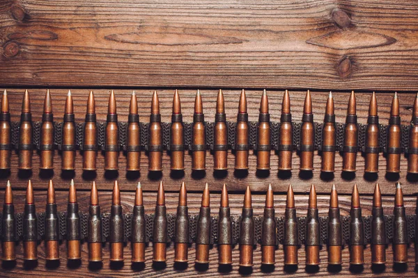 metal bullets in rows on wooden background