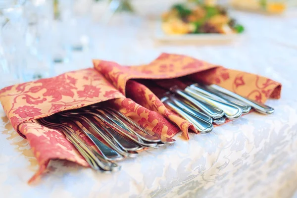 Cutlery in patterned tissue on catering service banquet