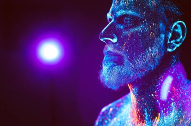 Kavram. Sakallı bir adam portresi. Adam ultraviyole toz boyalı.