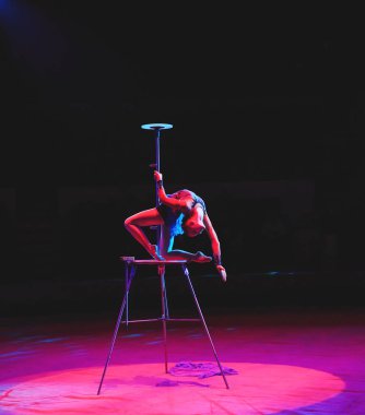 Hava acrobat içinde belgili tanımlık çalmak. Genç bir kız akrobatik öğeleri hava ringde gerçekleştirir..