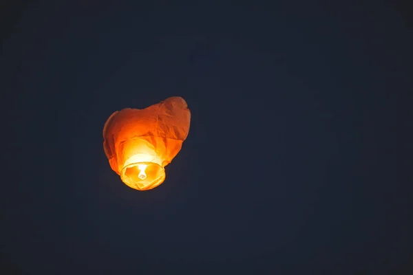 Flying chinese lantern in dark sky