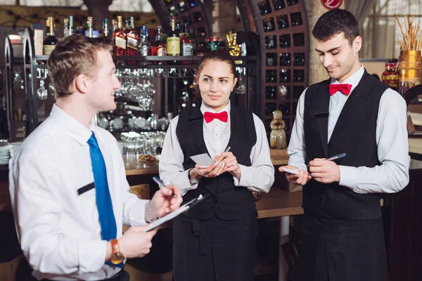 Manager's briefing with the waiters. Restaurant manager and his staff.