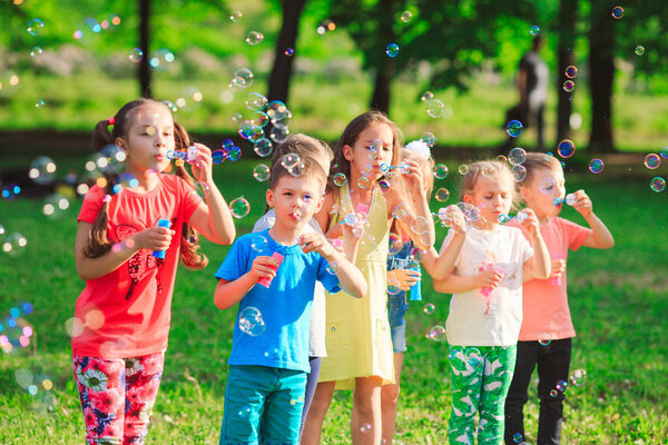 Group of children blowing soap bubbles