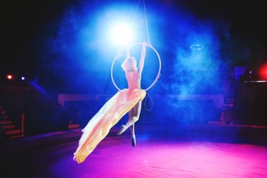 Hava acrobat içinde belgili tanımlık çalmak. Genç bir kız akrobatik öğeleri hava ringde gerçekleştirir..