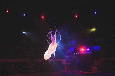 Hava acrobat içinde belgili tanımlık çalmak. Genç bir kız akrobatik öğeleri hava ringde gerçekleştirir..