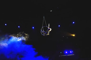Hava acrobat içinde belgili tanımlık çalmak. Genç bir kız akrobatik öğeleri hava ringde gerçekleştirir..