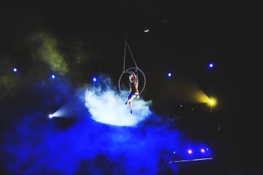 Hava acrobat içinde belgili tanımlık çalmak. Genç bir kız akrobatik öğeleri hava ringde gerçekleştirir..