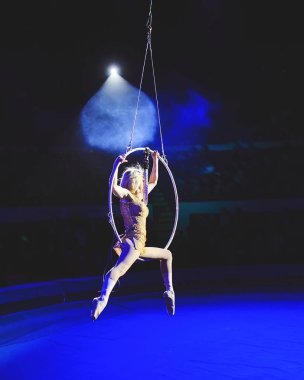 Hava acrobat içinde belgili tanımlık çalmak. Genç bir kız akrobatik öğeleri hava ringde gerçekleştirir..