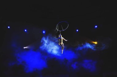 Hava acrobat içinde belgili tanımlık çalmak. Genç bir kız akrobatik öğeleri hava ringde gerçekleştirir..
