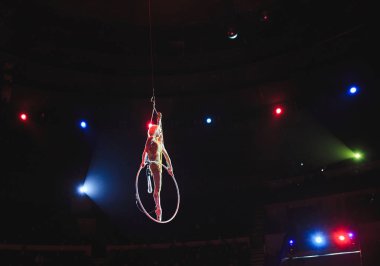 Hava acrobat içinde belgili tanımlık çalmak. Genç bir kız akrobatik öğeleri hava ringde gerçekleştirir..