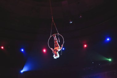 Hava acrobat içinde belgili tanımlık çalmak. Genç bir kız akrobatik öğeleri hava ringde gerçekleştirir..