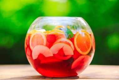 Yaz kokteyli. Yeşil arka planda meyve kokteyli. Narenciye, çilek, çilek, yaban mersini, nane, buz