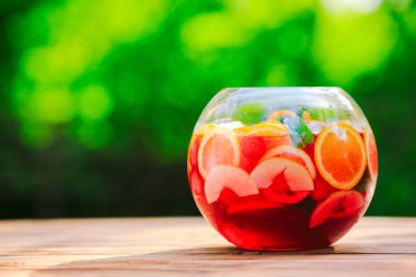 Yaz kokteyli. Yeşil arka planda meyve kokteyli. Narenciye, çilek, çilek, yaban mersini, nane, buz