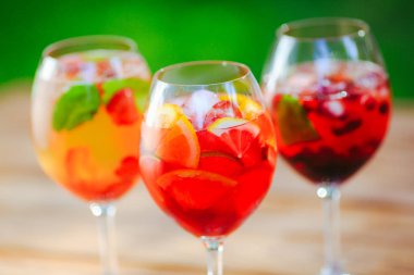 Yaz kokteyli. Yeşil arka planda meyve kokteyli. Narenciye, çilek, çilek, yaban mersini nane buz