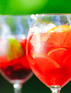 Yaz kokteyli. Yeşil arka planda meyve kokteyli. Narenciye, çilek, çilek, yaban mersini, nane, buz