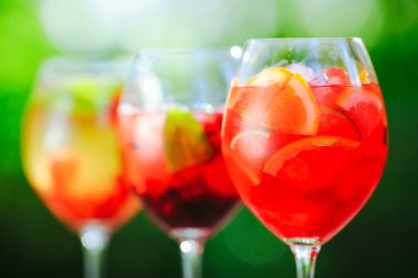 Yaz kokteyli. Yeşil arka planda meyve kokteyli. Narenciye, çilek, çilek, yaban mersini, nane, buz