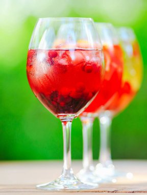 Yaz kokteyli. Yeşil arka planda meyve kokteyli. Narenciye, çilek, çilek, yaban mersini, nane, buz