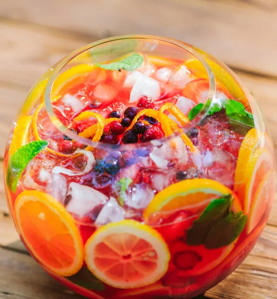 Summer cocktail. Fruit cocktail on green background. Citrus fruits, berries, strawberries, blueberries, mint, ice