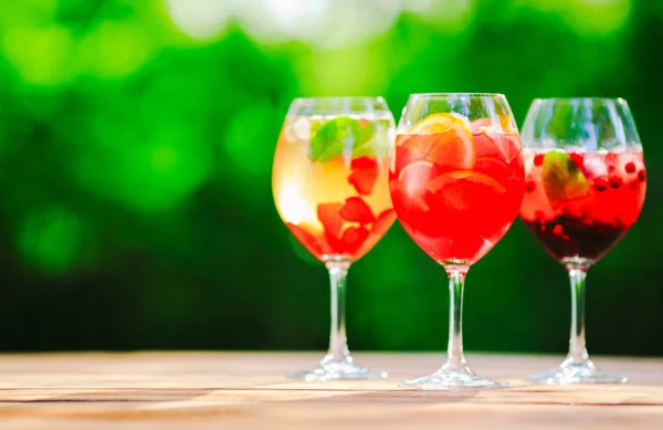 Summer cocktail. Fruit cocktail on green background. Citrus fruits, berries, strawberries, blueberries mint ice