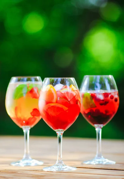 Summer cocktail. Fruit cocktail on green background. Citrus fruits, berries, strawberries, blueberries mint ice