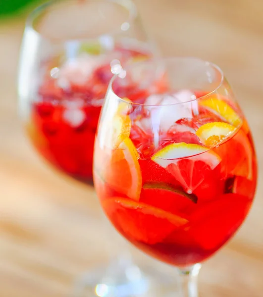 Summer cocktail. Fruit cocktail on green background. Citrus fruits, berries, strawberries, blueberries mint ice