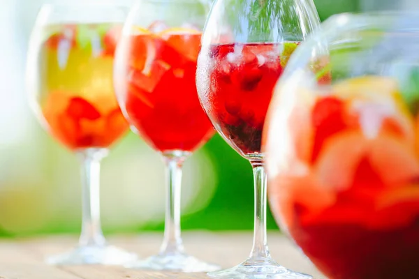 Summer cocktail. Fruit cocktail on green background. Citrus fruits, berries, strawberries, blueberries, mint, ice
