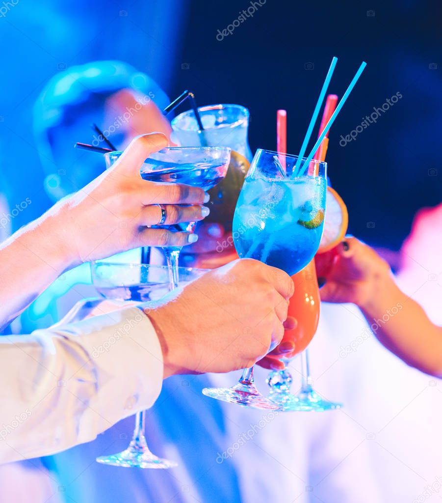 Friends with cocktails drinks at a party.