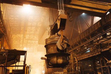 Çelik fabrikasında metalin erimesi. Eriyen ocakta yüksek sıcaklık. Metalürji endüstrisi. Metal borular üreten bir fabrika. Metali kalıplara doldurmak için kova.