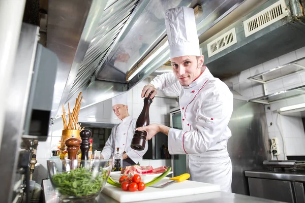 Şef restoranın mutfağında yemek hazırlıyor..