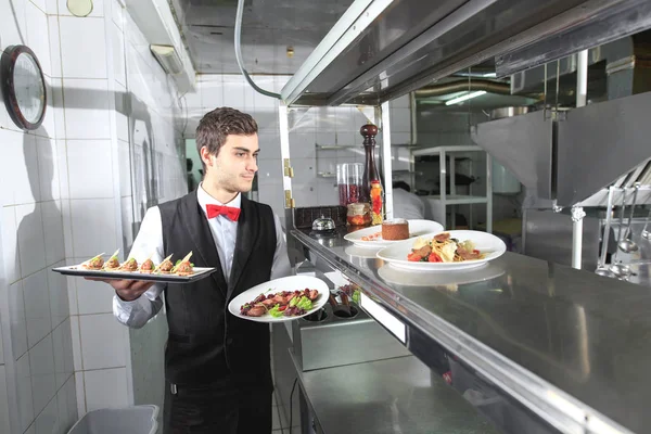 Cameriere Con Piatti Pronti Nella Cucina Del Ristorante — Foto Stock