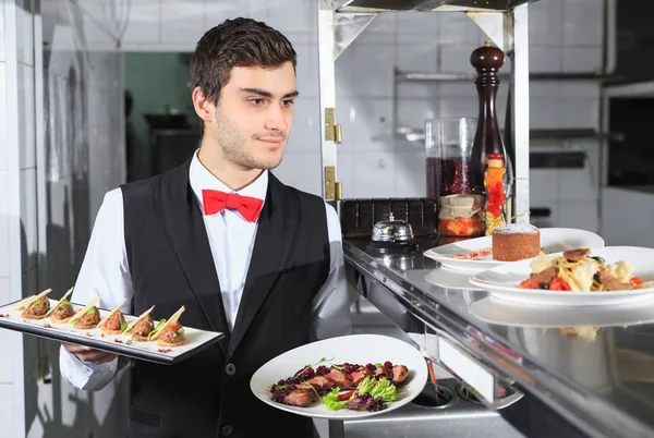 Cameriere Con Piatti Pronti Nella Cucina Del Ristorante — Foto Stock