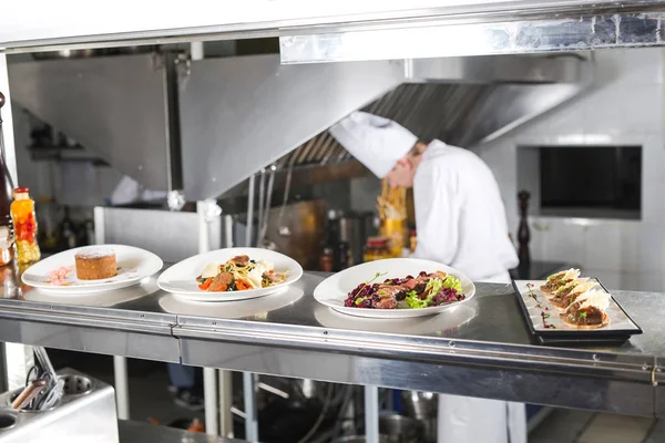 Distributionsbordet Restaurangens Kök Kocken Tillagar Måltid Bakgrunden Färdiga Rätterna — Stockfoto