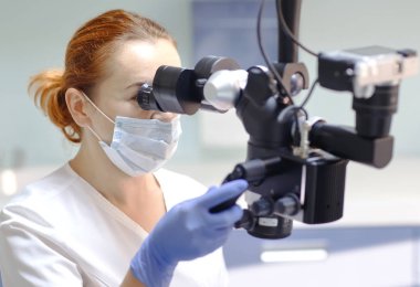 Kadın dişçi diş araçları - mikroskop, ayna ve diş Kliniği ofisindeki hasta diş tedavi sonda ile. Tıp, diş hekimliği ve sağlık kavramı. Diş ekipman