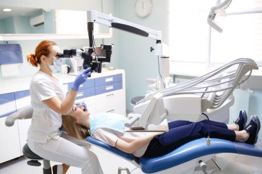 Kadın dişçi diş araçları - mikroskop, ayna ve diş Kliniği ofisindeki hasta diş tedavi sonda ile. Tıp, diş hekimliği ve sağlık kavramı. Diş ekipman