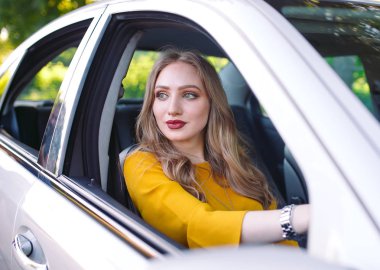 Genç bir kız araba kullanıyor..