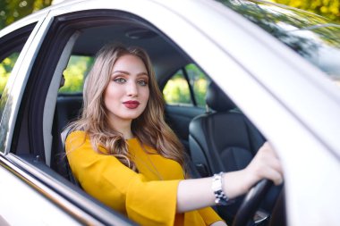 Genç bir kız araba kullanıyor..