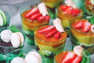 Plastik bardaklarda tatlılar taze çilek ile dekore edilmiştir.