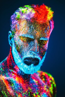 Kavram. Berber dükkanında sakallı bir adam. Berber dükkanında şık bir sakallı adam kesilmiş. Adam ultraviyole tozu ile dekore edilmiştir.