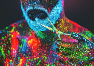 Kavram. Berber dükkanında sakallı bir adam. Berber dükkanında şık bir sakallı adam kesilmiş. Adam ultraviyole tozu ile dekore edilmiştir.