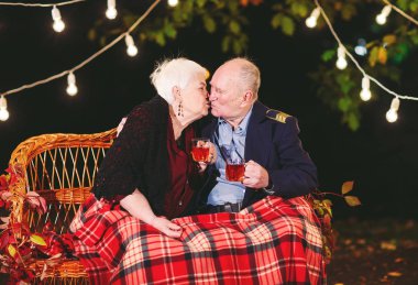 Mutlu yaşlı çift kanepede oturan akşam çay içme.