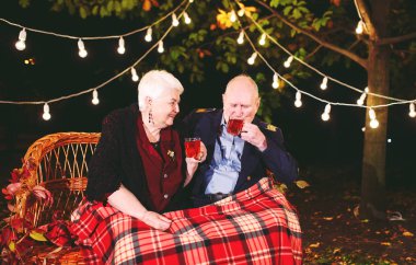 Mutlu yaşlı çift kanepede oturan akşam çay içme.