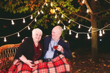 Mutlu yaşlı çift kanepede oturan akşam çay içme.