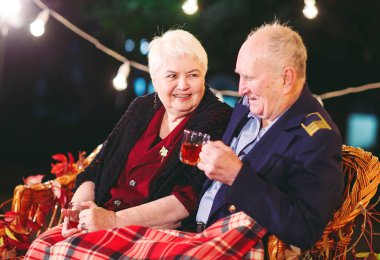 Mutlu yaşlı çift kanepede oturan akşam çay içme.