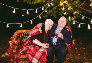 Mutlu yaşlı çift kanepede oturan akşam çay içme.