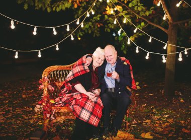 Mutlu yaşlı çift kanepede oturan akşam çay içme.