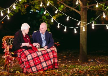 Mutlu anılar. Mutlu yaşlı çift fotoğraf ile albüm izlerken kanepede oturan.