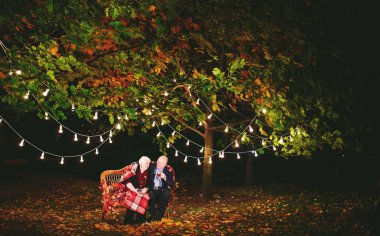 Mutlu yaşlı çift kanepede oturan akşam çay içme.