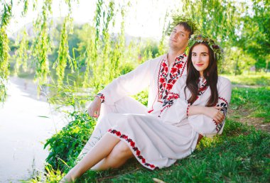 Midsummer. Gölün kıyısında Slav kostümleri genç seven çift. Ivan Kupala Slav tatili.