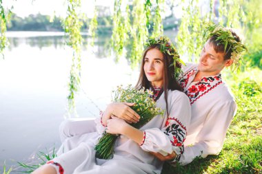 Midsummer. Gölün kıyısında Slav kostümleri genç seven çift. Ivan Kupala Slav tatili.