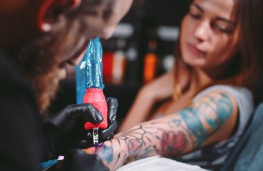 Profesyonel dövmeci dövme bir genç kızın elini üzerinde yapar..